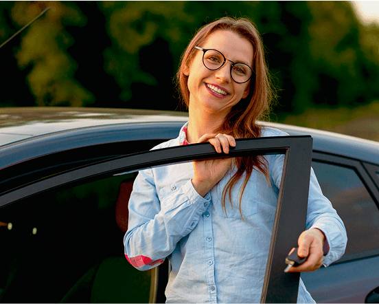 Femme heureuse sortant d'une voiture